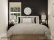 Modern bedroom with a round mirror, lamps, and neutral color palette at 8432 Norman Forest Rd, Lancaster, SC 29720