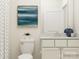 Clean bathroom with a white toilet, vanity, and neutral wall art, showcasing a simple and elegant design at 8442 Norman Forest Rd, Lancaster, SC 29720