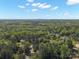 An aerial view showcases the city skyline in the distance beyond treetops at 8707 Copenhagen Ln, Charlotte, NC 28216