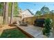 A wooden patio boasts an outdoor dining set, grill, and lush landscaping at 8707 Copenhagen Ln, Charlotte, NC 28216
