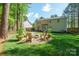 Spacious backyard with lush lawn, mature trees, fire pit area and patio at 8707 Copenhagen Ln, Charlotte, NC 28216