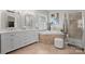 Bright bathroom with dual vanities, soaking tub, stand up shower and neutral tile at 8707 Copenhagen Ln, Charlotte, NC 28216