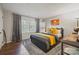 Comfortable bedroom with a large window and hardwood floors features a yellow color scheme creating a vibrant feel at 8707 Copenhagen Ln, Charlotte, NC 28216