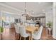 Elegant dining area with hardwood floors, stylish chandelier, and seamless flow into the living room at 8707 Copenhagen Ln, Charlotte, NC 28216