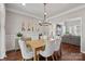 Open dining space with hardwood floors, an elegant light fixture, and views into the living room at 8707 Copenhagen Ln, Charlotte, NC 28216