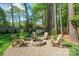 Outdoor fire pit and seating area nestled amongst mature trees at 8707 Copenhagen Ln, Charlotte, NC 28216