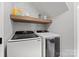 Functional laundry room with modern washer and dryer units and overhead storage shelf at 8707 Copenhagen Ln, Charlotte, NC 28216