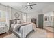 Comfortable primary bedroom with neutral décor, ceiling fan, and ensuite bathroom entrance at 8707 Copenhagen Ln, Charlotte, NC 28216