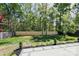 View of a spacious backyard with a privacy fence and lush trees behind the yard at 8811 Steelechase Dr, Charlotte, NC 28273