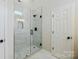 Bathroom showcasing a glass enclosed shower with white tile surround and black hardware at 8811 Steelechase Dr, Charlotte, NC 28273