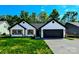 Charming single-story home featuring a black roof, wooden shutters, a two-car garage and a well-maintained green lawn at 8811 Steelechase Dr, Charlotte, NC 28273