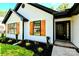 Stylish single-story home featuring black accents, wooden shutters and a well-manicured garden near the front entrance at 8811 Steelechase Dr, Charlotte, NC 28273