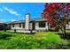 The home's exterior features a well-maintained lawn and a bright red maple tree for curb appeal at 8811 Steelechase Dr, Charlotte, NC 28273