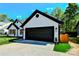 Contemporary home boasting a sleek black two-car garage, a black roof, and landscaped yard with artificial turf at 8811 Steelechase Dr, Charlotte, NC 28273