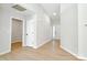 Bright hallway featuring wood floors, white walls, and doors leading to various rooms in the home at 8811 Steelechase Dr, Charlotte, NC 28273
