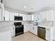 Modern kitchen with white cabinets, stainless steel appliances, tile backsplash, and wood floors at 8811 Steelechase Dr, Charlotte, NC 28273
