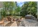 Backyard with brick-paved area, fire pit with Adirondack chairs, and natural shade at 8929 Lizzie Ln, Huntersville, NC 28078