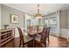 Dining room featuring hardwood floors, elegant light fixture, and natural light from large windows at 8929 Lizzie Ln, Huntersville, NC 28078