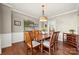 Spacious dining room with hardwood floors, elegant lighting fixture, and wainscoting at 8929 Lizzie Ln, Huntersville, NC 28078