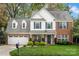 Charming two-story brick home featuring a well-manicured lawn and attached two car garage at 8929 Lizzie Ln, Huntersville, NC 28078
