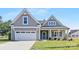 Charming home exterior features a well-manicured lawn, a two-car garage and inviting front porch at 908 Cypress Point Ln # 218, Monroe, NC 28112