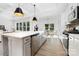 Bright, modern kitchen boasts stainless steel appliances, quartz countertops, and island with pendant lighting at 908 Cypress Point Ln # 218, Monroe, NC 28112
