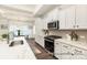 Bright kitchen featuring white cabinets, countertops, a modern backsplash, and stainless steel appliances at 908 Cypress Point Ln # 218, Monroe, NC 28112