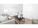 Bright living room featuring neutral sofa, a black coffee table, and natural light at 908 Cypress Point Ln # 218, Monroe, NC 28112