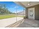 The covered screened-in porch overlooks a scenic backyard and blue sky on a sunny day at 908 Cypress Point Ln # 218, Monroe, NC 28112