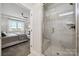 Ensuite bathroom featuring a glass shower and view of the primary bedroom with a large window at 920 Exeter Dr, Sherrills Ford, NC 28673