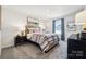 Comfortable bedroom with a plaid-covered bed, neutral decor, and ample natural light from the window at 920 Exeter Dr, Sherrills Ford, NC 28673