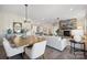 Open-concept living room with stone fireplace, neutral furniture, light wood floors, and view into kitchen and dining area at 920 Exeter Dr, Sherrills Ford, NC 28673