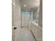 Bright bathroom with a white subway tile shower, dual vanity sink, black and white tiled floors, and natural light at 9508 Hayenridge Ct, Huntersville, NC 28078