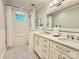 Bright bathroom featuring a shower-tub combo, modern vanity with double sinks, and stylish black and white flooring at 9508 Hayenridge Ct, Huntersville, NC 28078