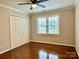 Bedroom featuring hardwood floors, ceiling fan, a double window, and double door closet at 9508 Hayenridge Ct, Huntersville, NC 28078
