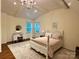Bedroom featuring vaulted ceiling, hardwood floors, chandelier, and a vanity with makeup mirror at 9508 Hayenridge Ct, Huntersville, NC 28078