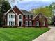 Imposing two-story brick home with lush lawn, manicured landscaping and black shutters exudes curb appeal at 9508 Hayenridge Ct, Huntersville, NC 28078