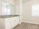 Bright bathroom featuring white cabinets, granite counters, a large mirror, and modern fixtures at 105 Tanner Loop, Troutman, NC 28166
