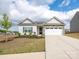 Charming one-story home featuring a stone veneer, manicured lawn, and a two-car garage at 105 Tanner Loop, Troutman, NC 28166