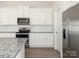 Bright kitchen featuring stainless steel appliances, white cabinetry, and granite countertops at 105 Tanner Loop, Troutman, NC 28166