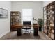 Well-lit office features wood desk with black chair, shelving, and large window at 105 Tanner Loop, Troutman, NC 28166