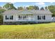 Attractive single-story home with stone foundation, lush lawn, and welcoming front porch at 1058 Canada Dr, Dallas, NC 28034
