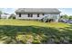 View of the back exterior with a deck and large grassy yard, complemented by neutral siding and a stone foundation at 1058 Canada Dr, Dallas, NC 28034