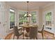 Inviting dining area with a round table, bay windows, and a modern chandelier, ideal for Gathering meals at 1090 Heather Glen Dr, Matthews, NC 28104