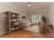 Cozy home office with natural light, a comfortable sofa, and a well-organized bookshelf for focused work at 1090 Heather Glen Dr, Matthews, NC 28104