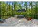 Backyard patio featuring modern seating, an umbrella, and lush greenery at 11040 E Lake Rd, Charlotte, NC 28215