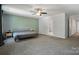 Bright and airy bedroom with a ceiling fan, two large windows, and neutral colors on the walls and carpet at 11040 E Lake Rd, Charlotte, NC 28215