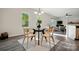 Bright dining area featuring a glass table with chairs, a decorative plant, and a view to the living room at 11040 E Lake Rd, Charlotte, NC 28215