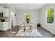Inviting dining area with a glass table, modern chairs, a stylish light fixture, and natural light at 11040 E Lake Rd, Charlotte, NC 28215