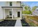 Inviting front porch with a seating area, manicured flowerbeds and stepping stone path at 11040 E Lake Rd, Charlotte, NC 28215